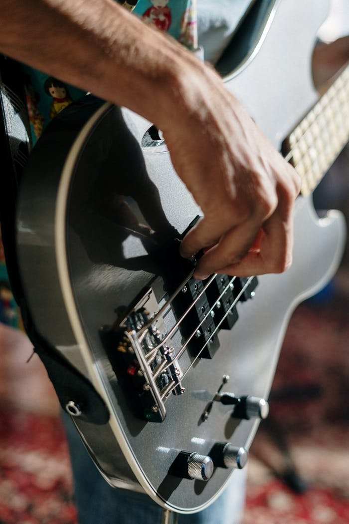 A musicians hand elegantly strumming an electric guitar during an intimate indoor performance.